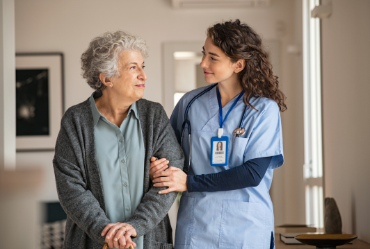 Elderly patient linking arms with a nurse