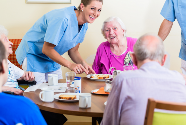 A nurse smiling with her elderly patient, in a nursing home