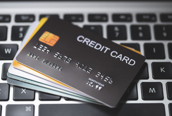 A pile of credit cards on top of a laptop keyboard.