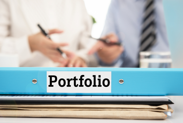 A portfolio folder in the foreground of two men talking