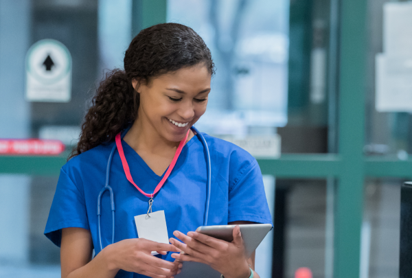 Nurse smiling while looking at an iPad