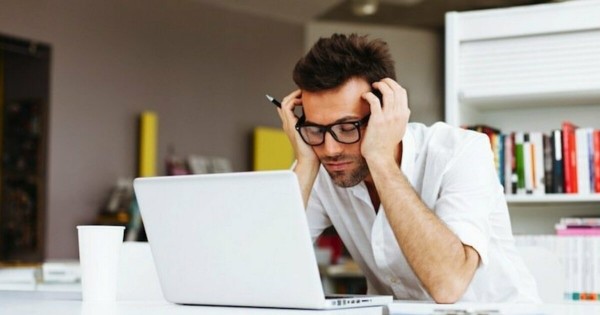 Guy looking stressed at his laptop