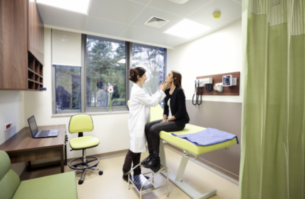 A general practitioner assessing a patient in her consultation room.