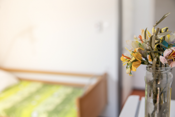 vase of flowers in an empty bedroom