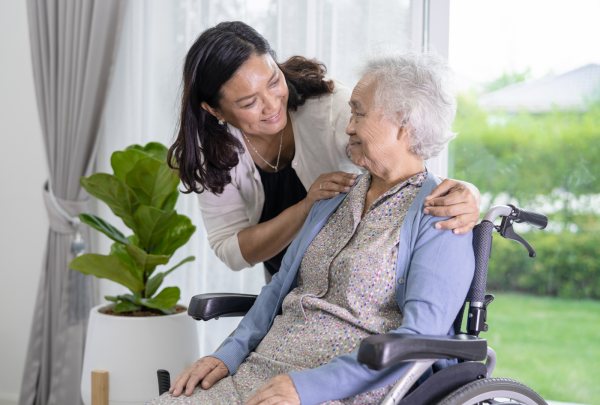 An elderly nursing home patient smiling at her nurse