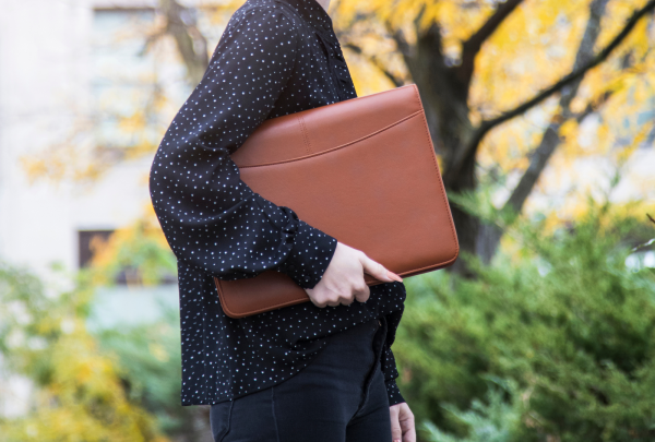 Women holding a brown leather folder